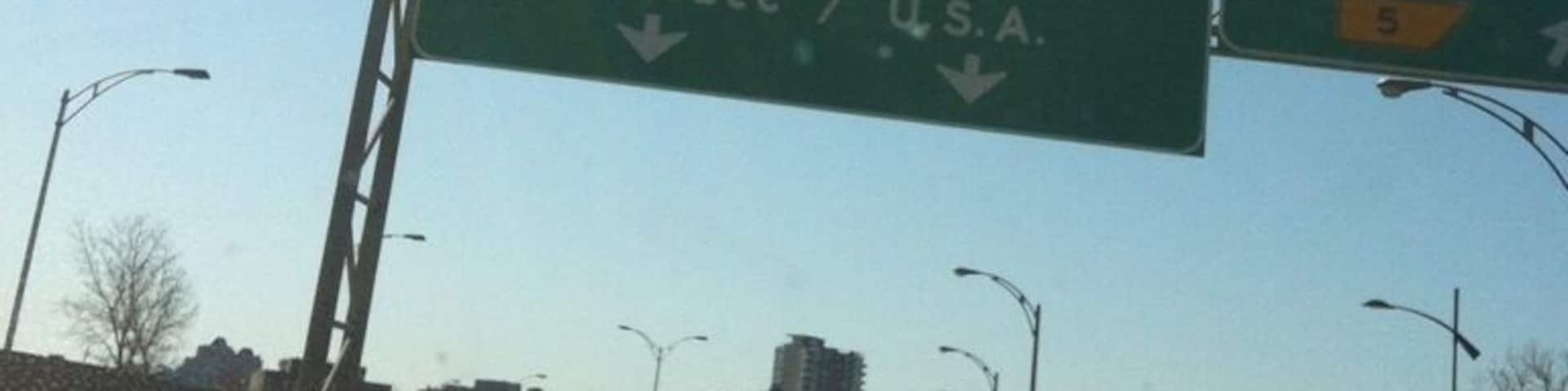 A highway sign with directions to Pont Champlain Bridge, Sherbrooke, Quebec, and the U.S.A.