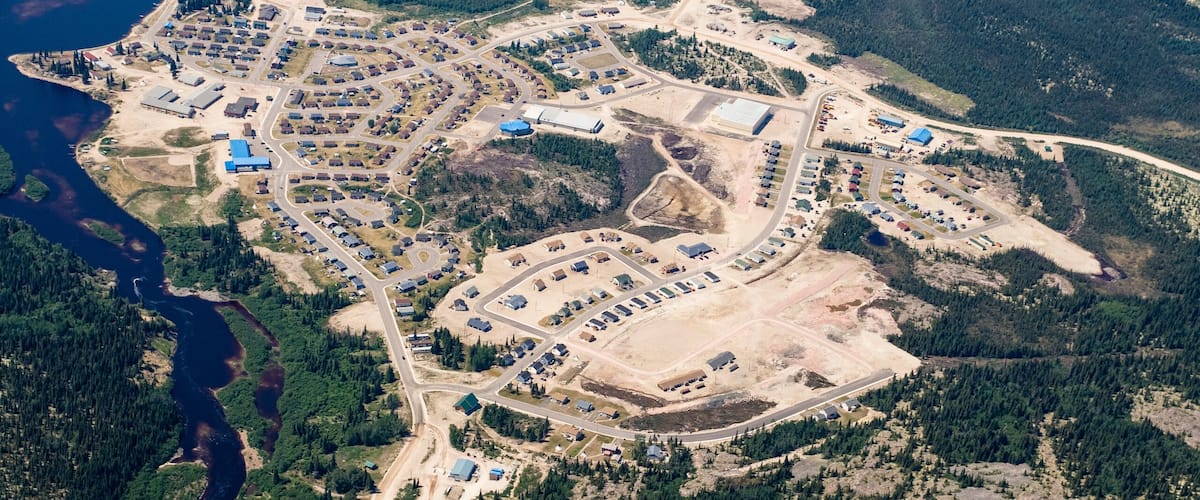 An aerial view of a coastal industrial area with multiple buildings, roads, and water bodies.