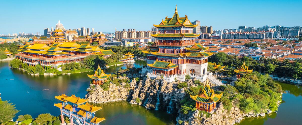 A traditional Chinese architectural complex with multiple pagodas and a large body of water.