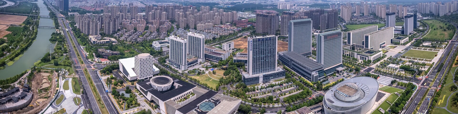 Un paisaje urbano con rascacielos, un río y una gran estructura circular.