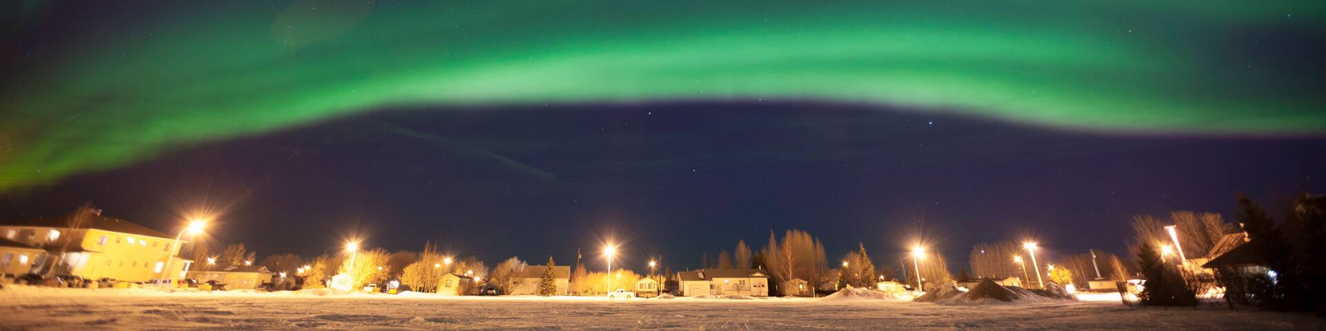 Idyllic view of aurora borealis over houses
