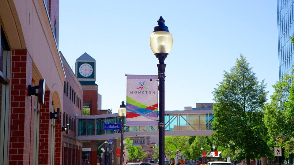 A street with buildings, a clock tower, and a banner.