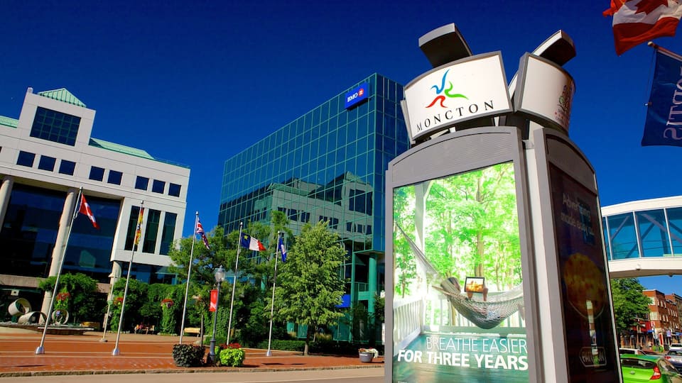 A cityscape with modern buildings, a sign for Moncton, and a hammock on a porch advertising 'Breathe Easier for Three Years'.