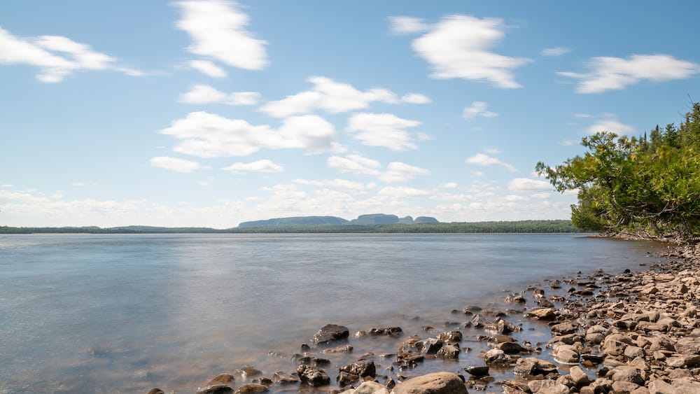 The mountain formation known as the Sleeping Giant is seen in the distance across a bay in Lake Superior on a bright sunny day.
