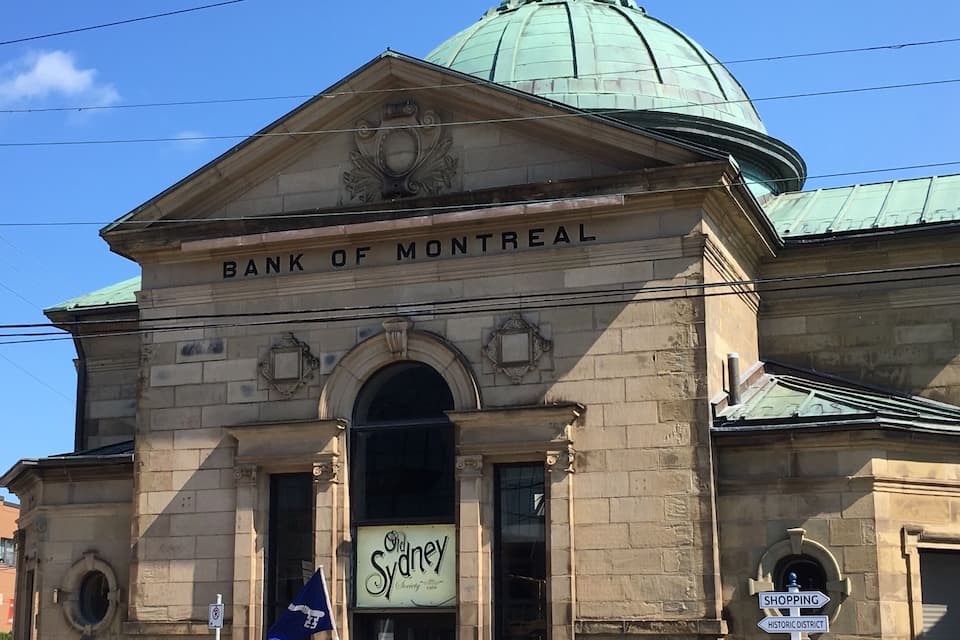 The exterior of the Bank of Montreal building with a dome and a sign for Old Sydney Society.