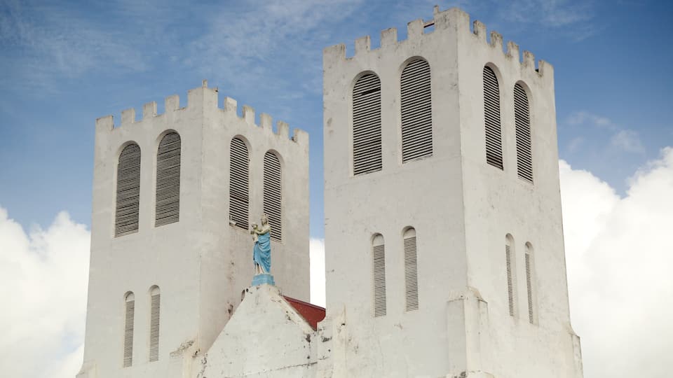 Dos torres blancas con ventanas arqueadas y una estatua en la base.