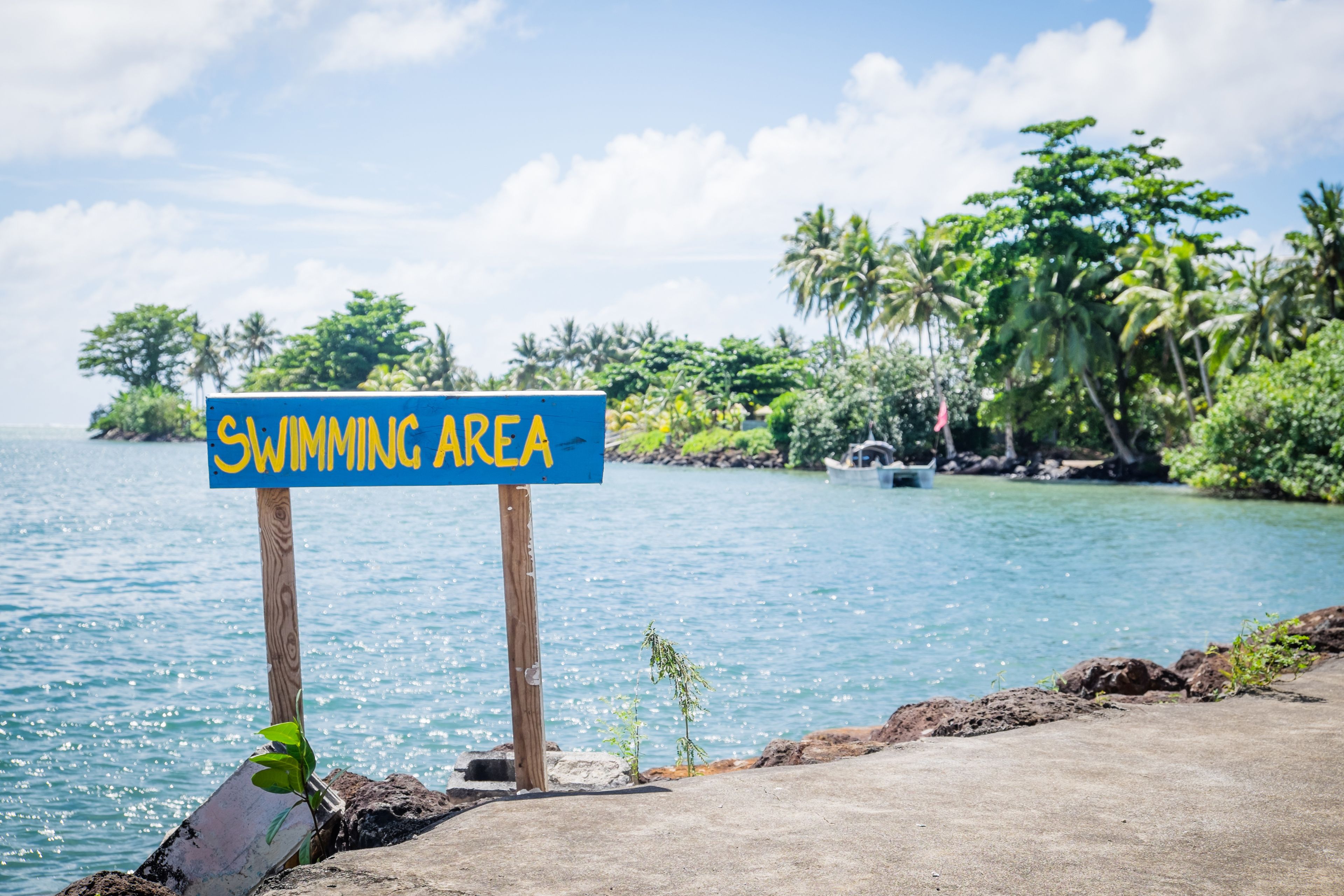 Sign for sea swimming area by Piula Cave Pool, Upolu Island, Samoa, South Pacific - lush tropical plants and foliage in background