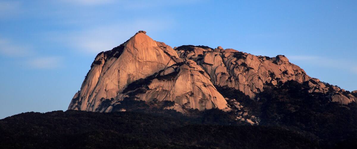 A large, rugged mountain with a prominent peak and steep slopes.