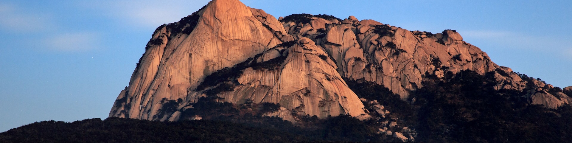 A large, rugged mountain with a prominent peak and steep slopes.