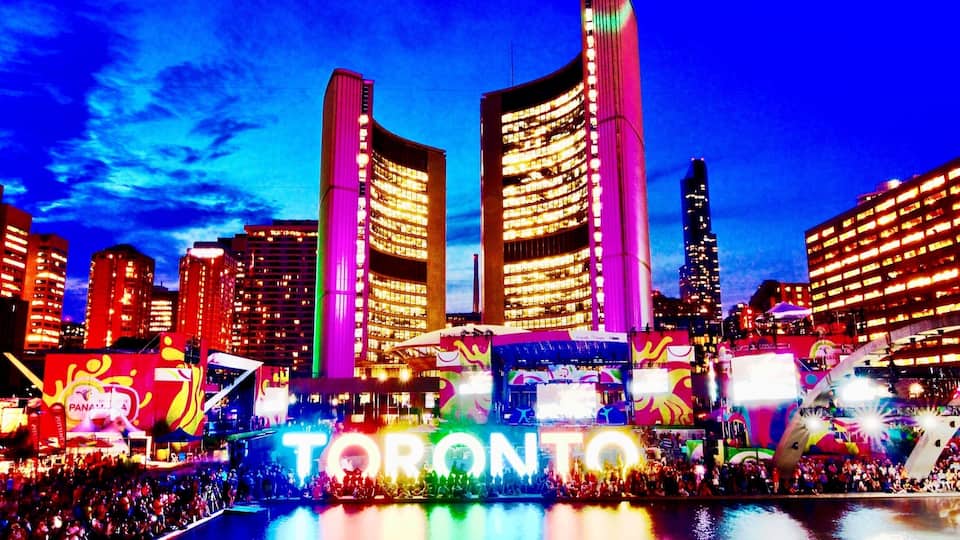 A brightly lit cityscape with the word "TORONTO" prominently displayed in the foreground.