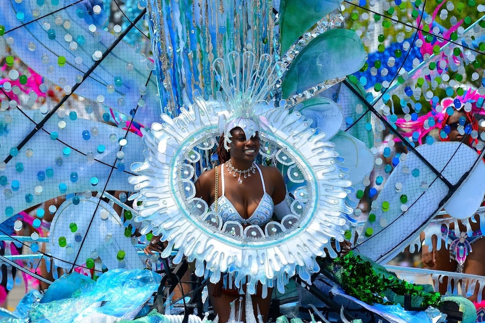 A person in a colorful, ornate costume with a large, decorative headpiece.