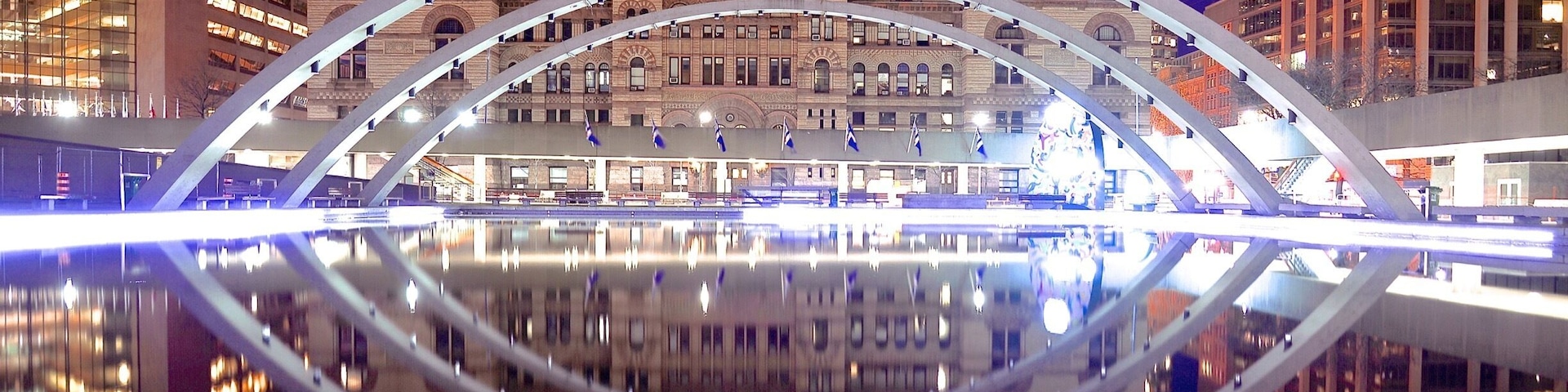 Eine moderne Brücke mit Spiegelung im Wasser, umgeben von historischen Gebäuden und hohen Wolkenkratzern.