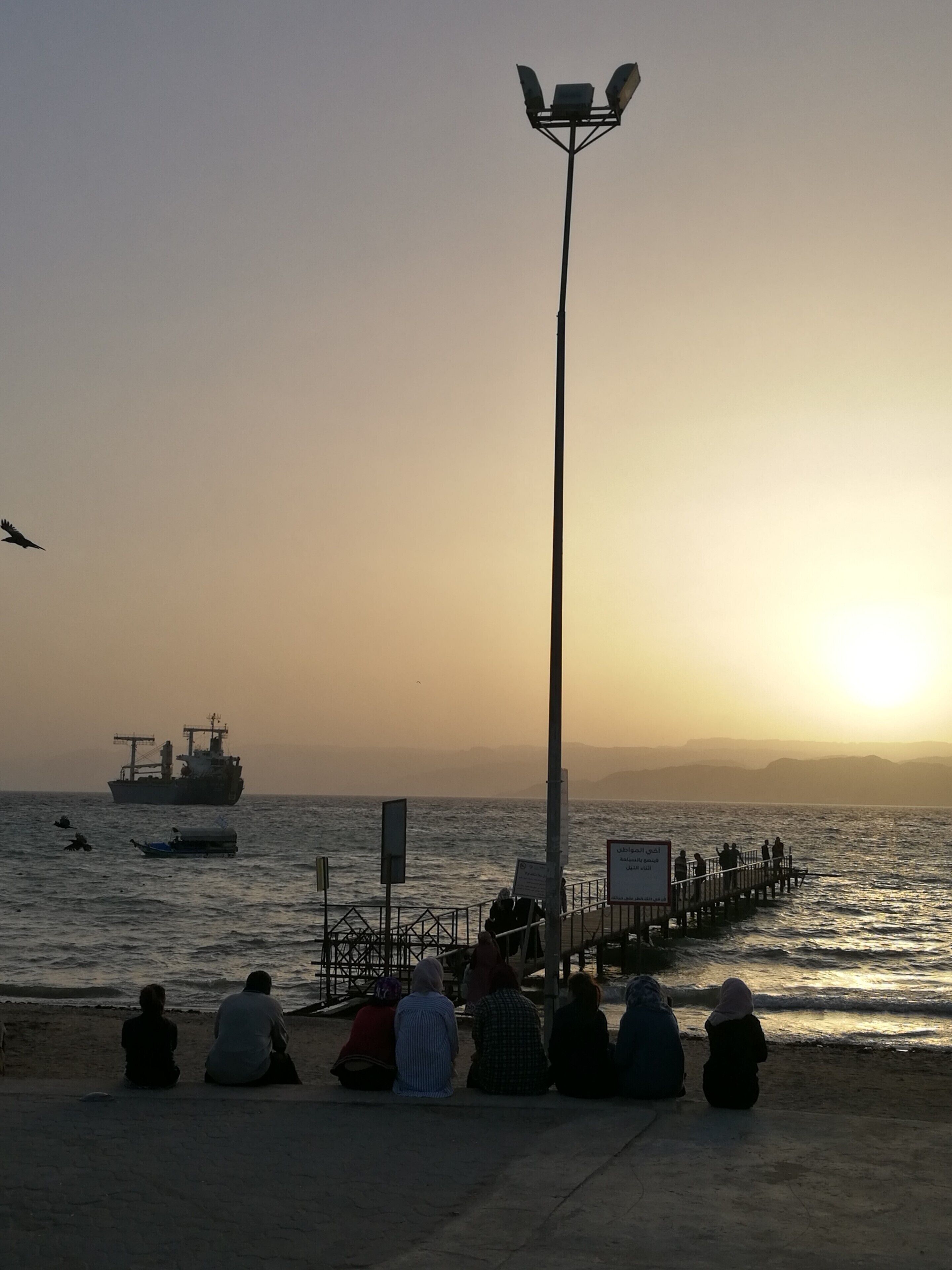 The locals rest on the city beach of Aqaba in Jordan watching the sunset to the Red Sea and the passing ships. The hills across the Aqaba bay is already Egypt. Travel tip: if you don't want to spend your time at the crowded by locals city beach go Tala Bay area - it's only 9 km from Aqaba and the quality of the beach and water is great  #LifeAtExpedia