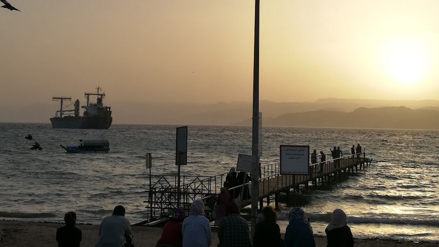 The locals rest on the city beach of Aqaba in Jordan watching the sunset to the Red Sea and the passing ships. The hills across the Aqaba bay is already Egypt. Travel tip: if you don't want to spend your time at the crowded by locals city beach go Tala Bay area - it's only 9 km from Aqaba and the quality of the beach and water is great #LifeAtExpedia