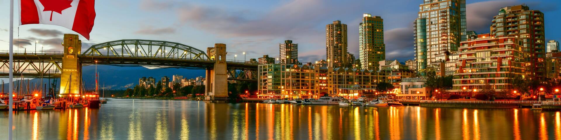 Canadian flag in front of view Granville island near Burrard Street Bridge at twilight in Vancouver,Canada