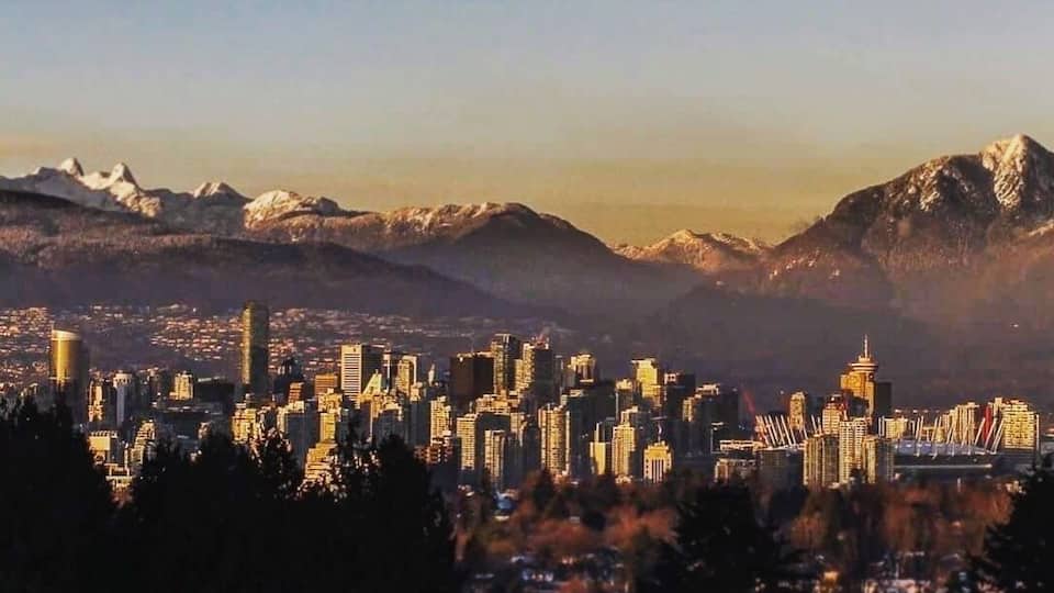 A cityscape with a mountain range in the background.