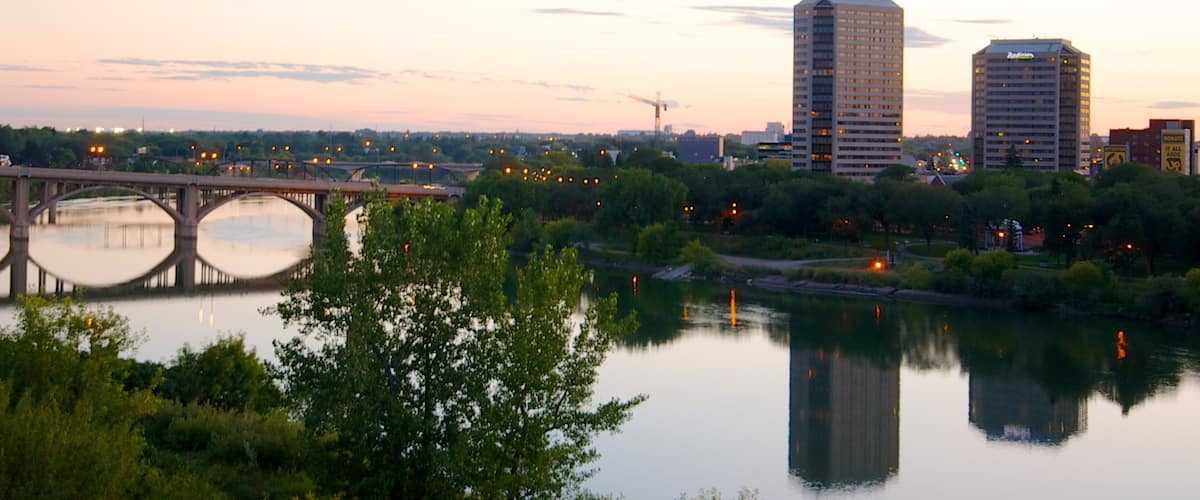 A river with a bridge, a city skyline, and buildings reflecting on the water.