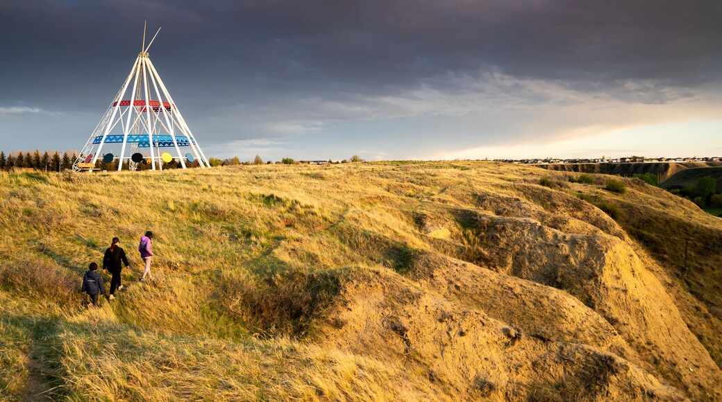 Medicine Hat Alberta Canada, May 13 2021: A family walks outdoors along a hiking trail in Seven Persons Coulee by the Sammis Tepee at sunset.
