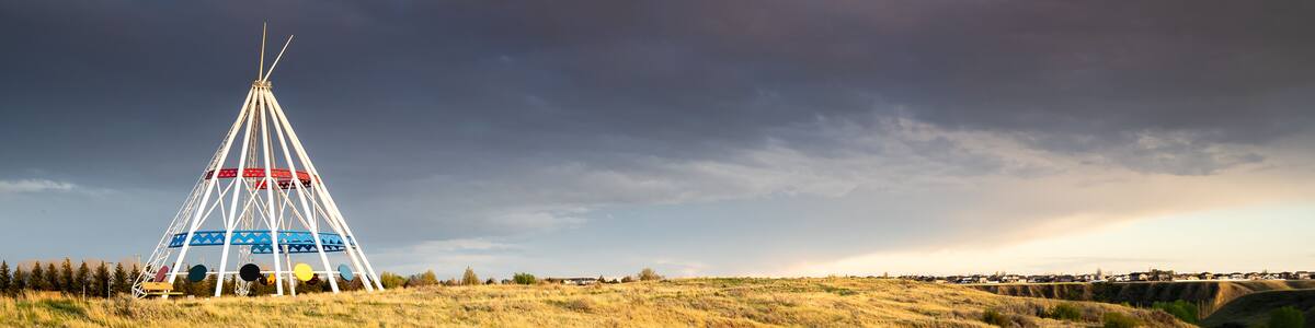 Medicine Hat Alberta Canada, May 13 2021: A family walks outdoors along a hiking trail in Seven Persons Coulee by the Sammis Tepee at sunset.