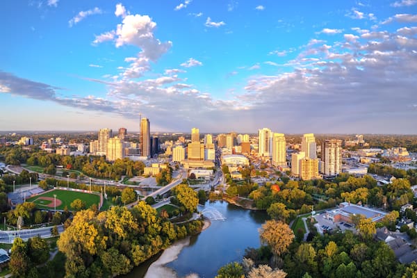 A cityscape with a river, green spaces, and tall buildings.