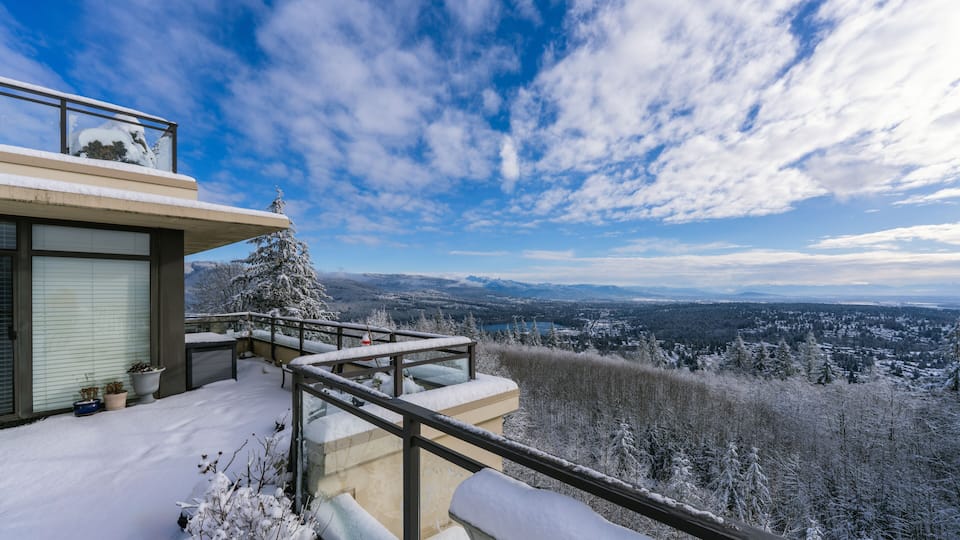 Snow on rooftop patio overlooking Fraser Valley, BC, Canada on a sunny winter day.