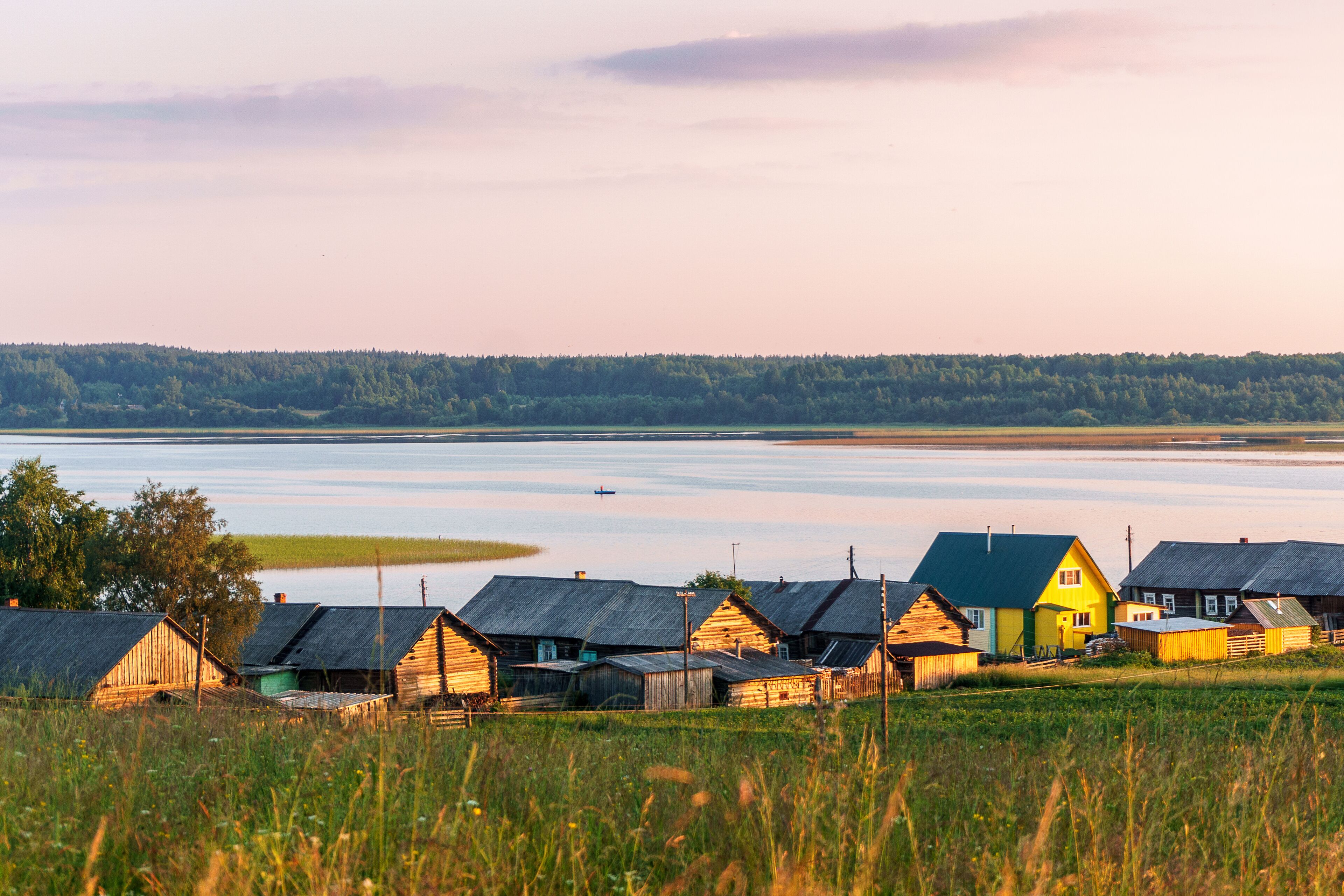Wooden church on the top of the hill. Vershinino village sunset view. Arkhangelsk region, Northern Russia.