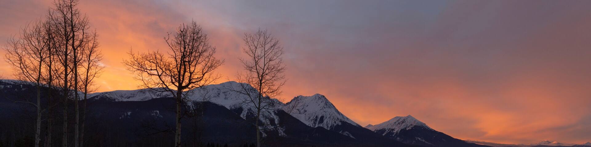 Sky glowing pink over snow-capped mountains from Watson's Landing, Smithers, BC; Smithers, British Columbia, Canada