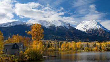 A lake surrounded by autumn-colored trees and snow-capped mountains.