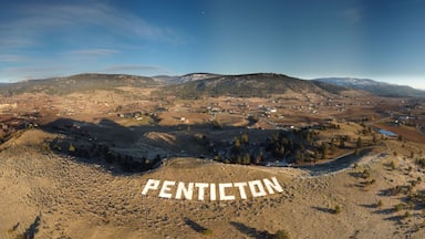 Vista panorámica de Penticton, con un valle, montañas y un río.
