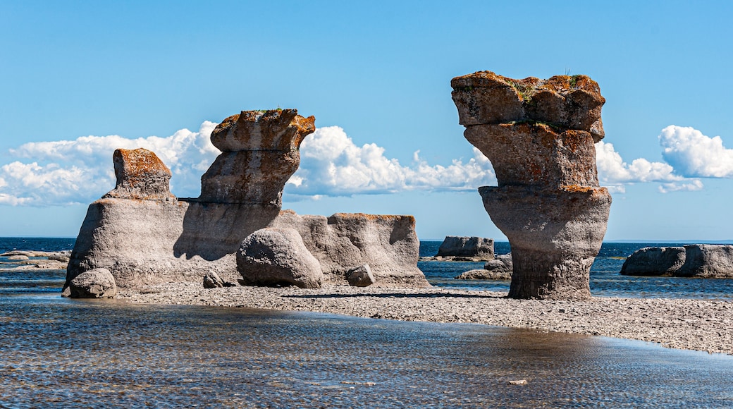 Rock formations with a clear sky and ocean in the background.