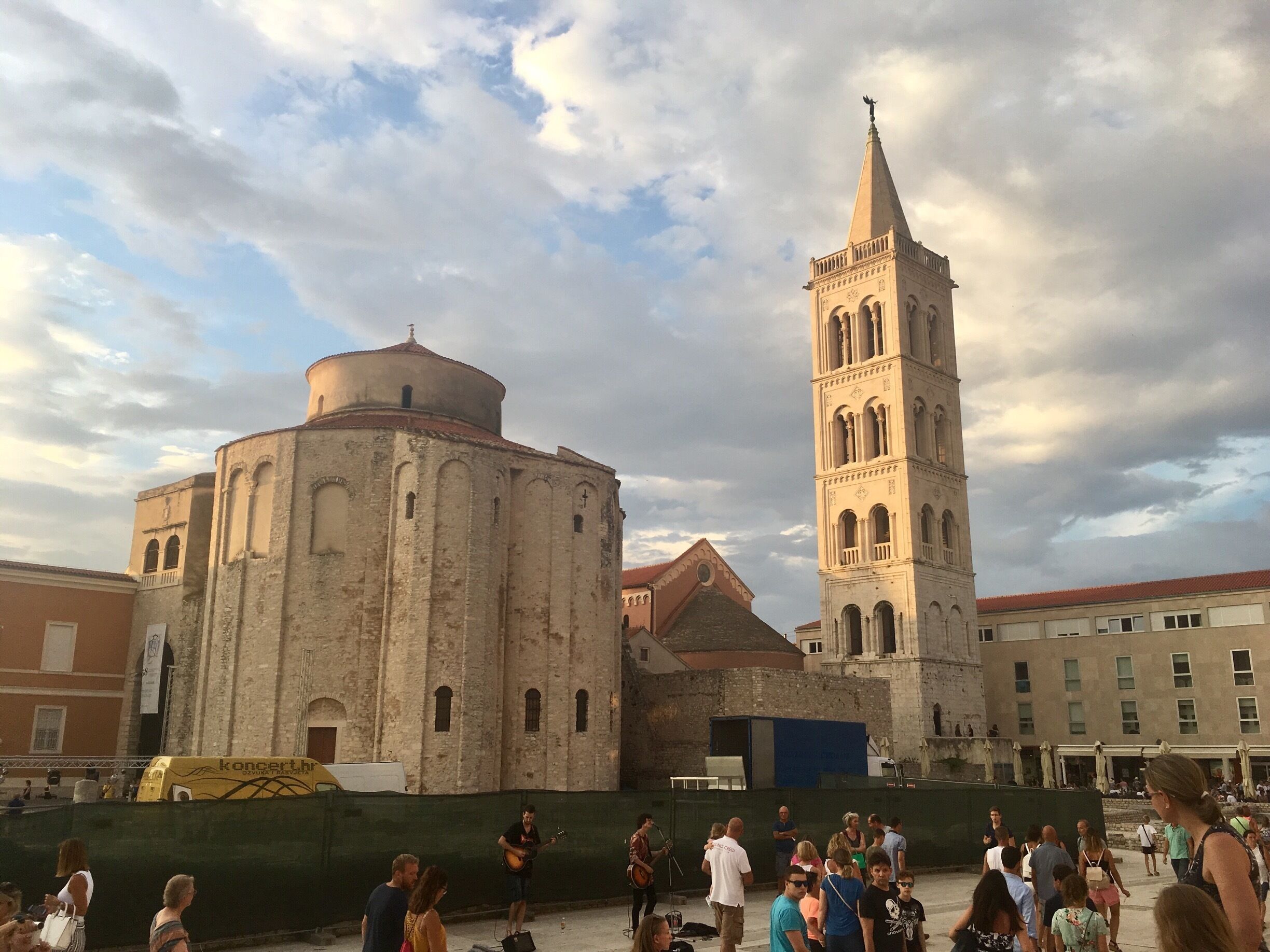 Una església històrica amb una torre campanar i una cúpula, envoltada d'una multitud de persones.