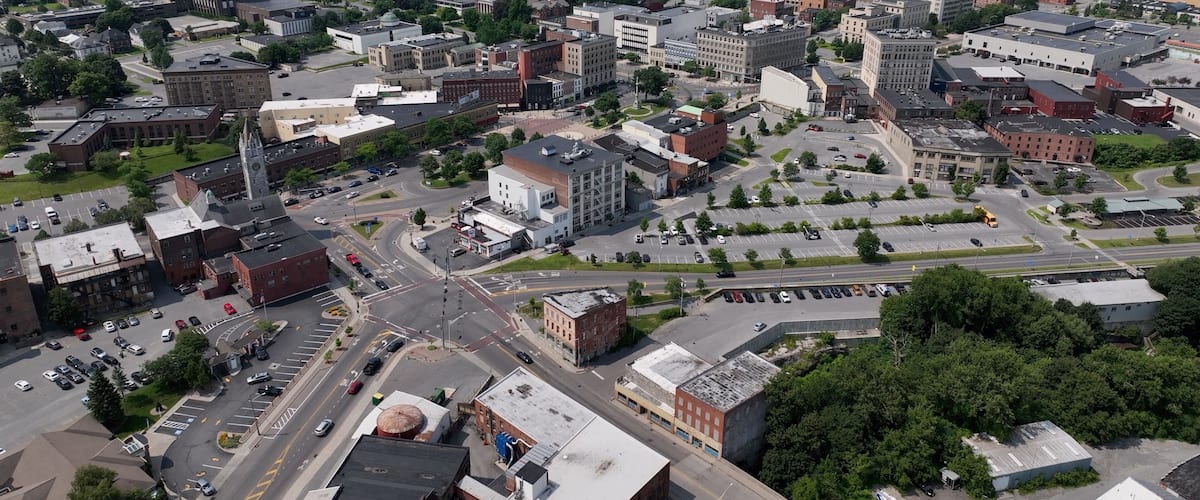 A cityscape with a mix of historic and modern buildings, a prominent church steeple, and a large open park area.