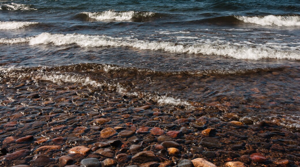 Waves rush over the eastern shoreline rocks of Trout Lake in Vilas County, near Boulder Junction, Wisconsin from a strong, south-westerly wind on a late-September morning.