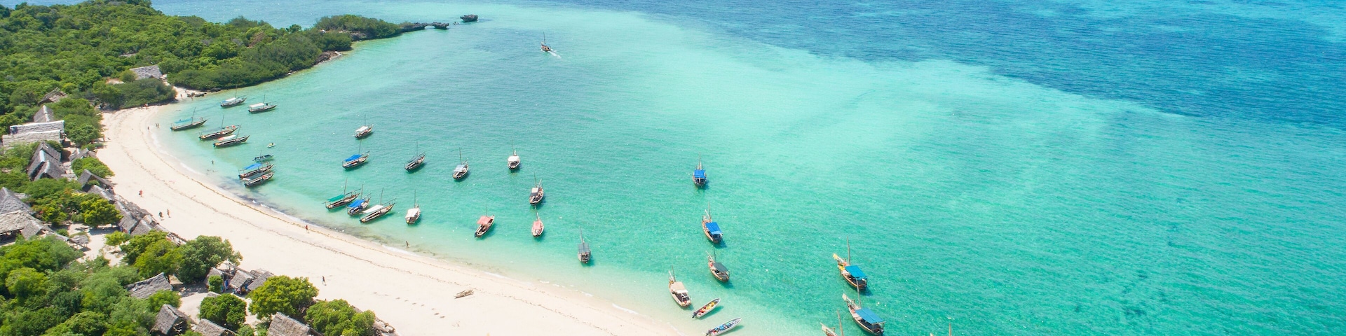 curved coast and beautiful beach with boats on Zanzibar island