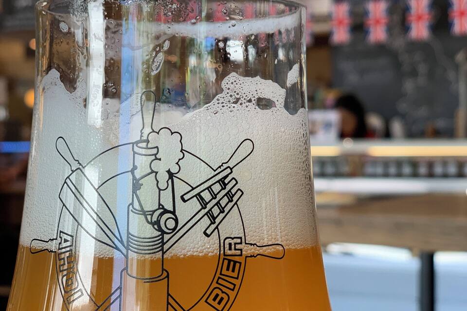 Ein Glas mit einem Bierlogo und einer Illustration eines Zapfhahns.