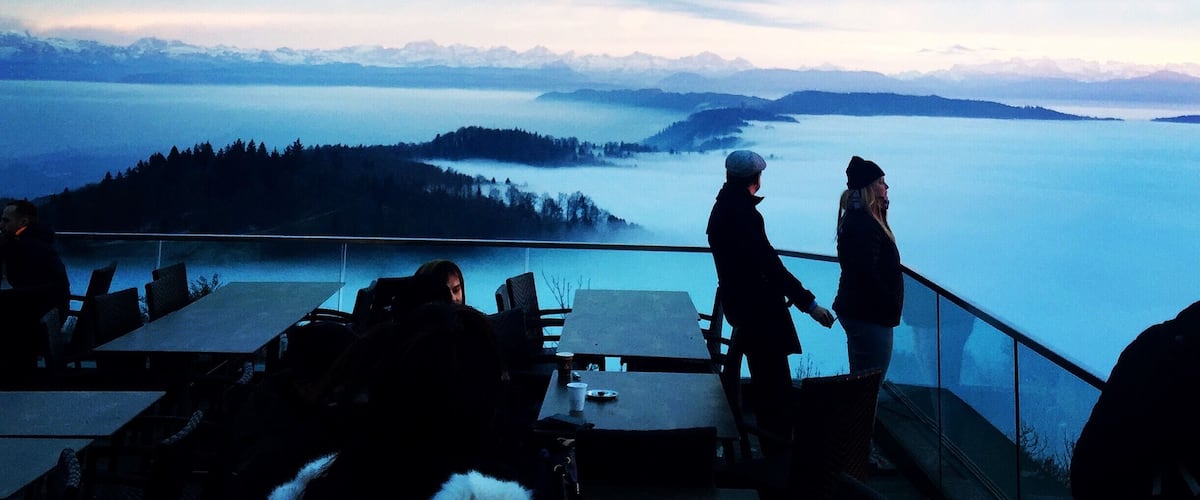 A scenic overlook with a view of a lake and distant mountains.