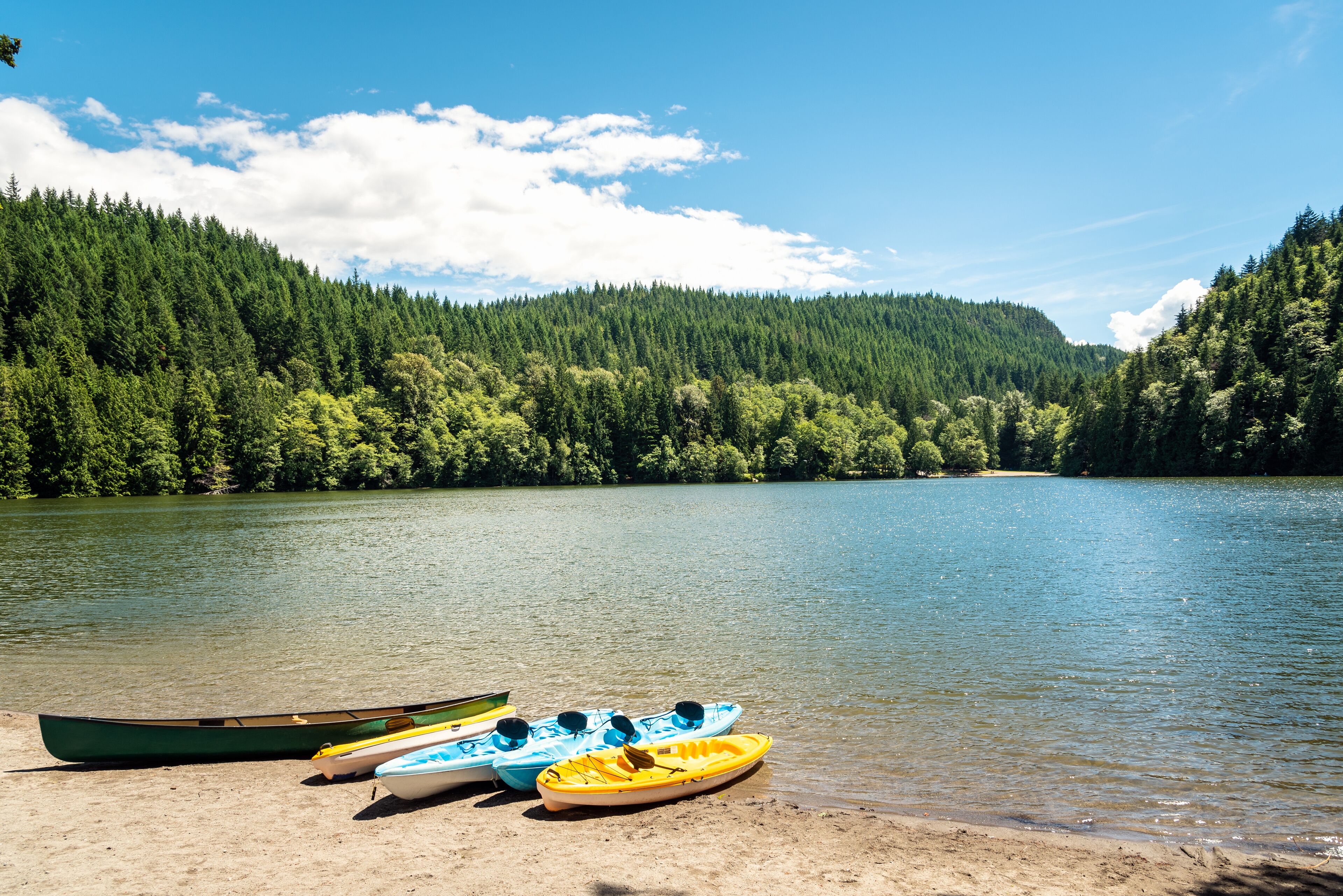 rawing boats on the sandy beach on a beautiful mountain lake