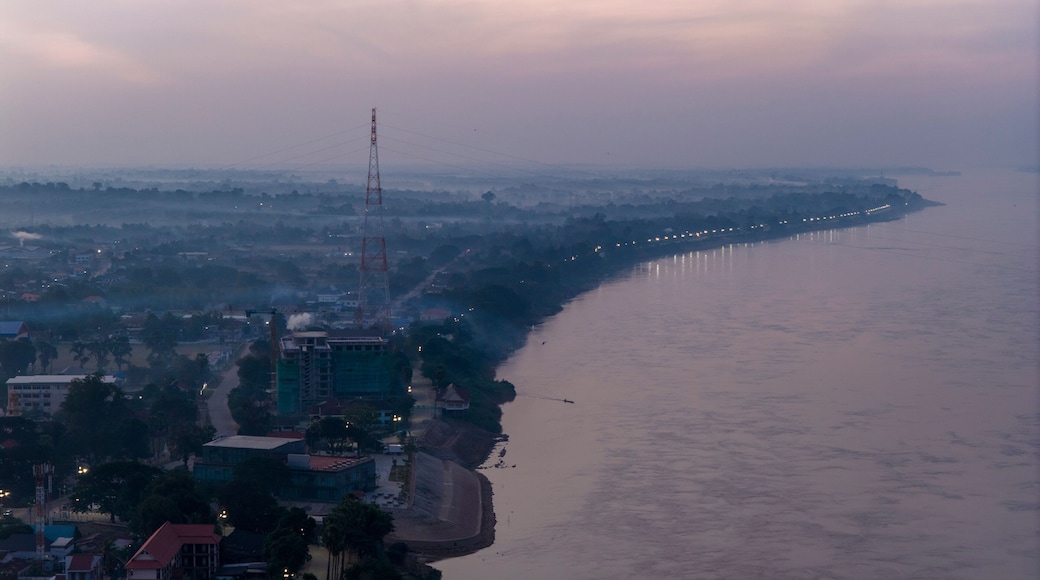 Blue hour aerial photography of Savannakhet. The deep blue sky contrasts with the warm artificial lights of the city, creating a moody atmosphere.