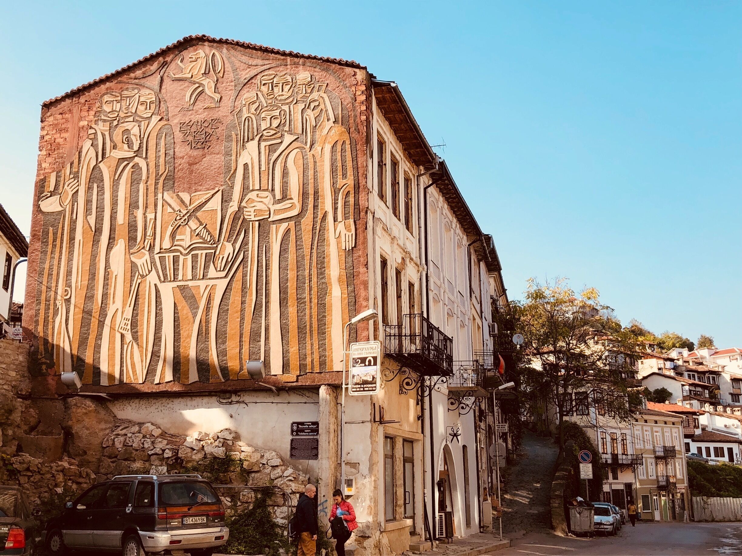 A building with a large mural of figures and hieroglyphs.