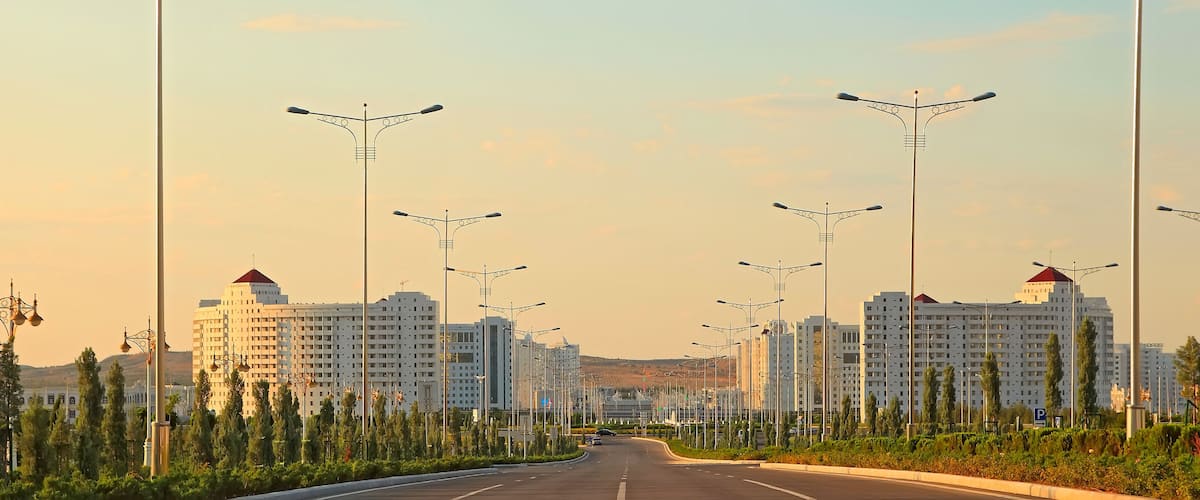 A wide, straight road lined with modern streetlights and tall residential buildings.