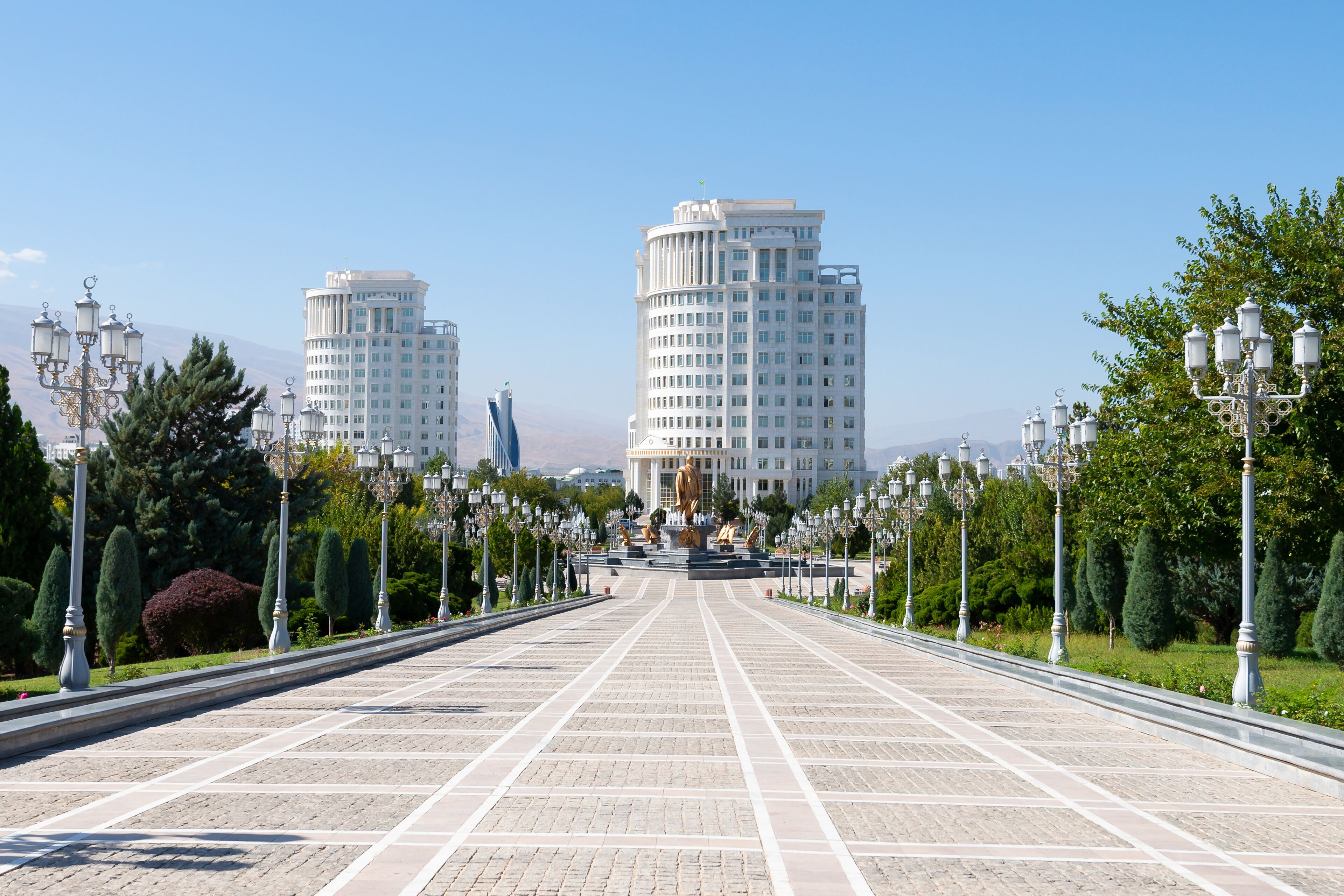 Ashgabat Independence Park in Turkmenistan. White marble buildings behind.