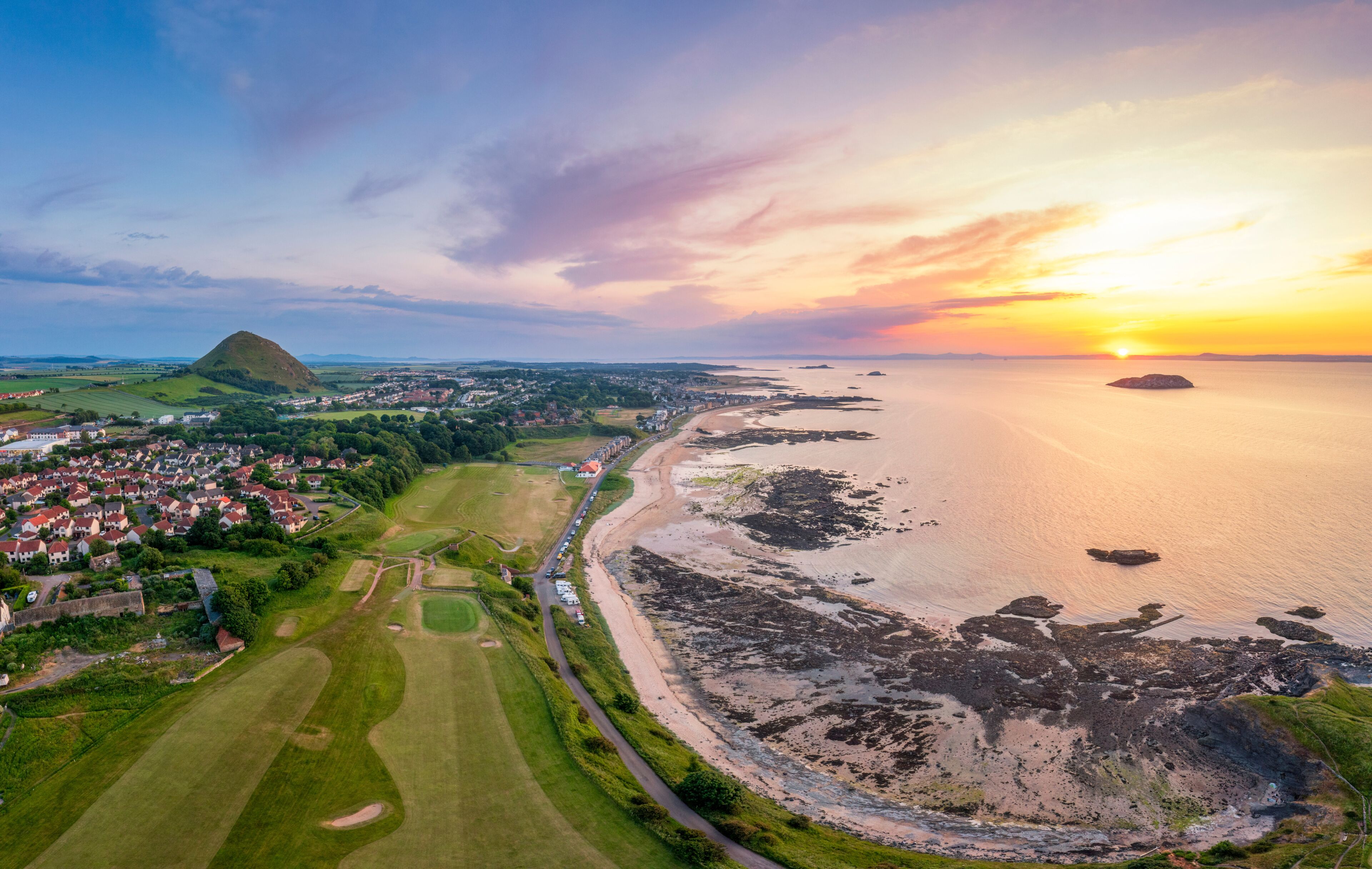 UK, Scotland, North Berwick, Aerial view of beach in front of coastal town at sunset