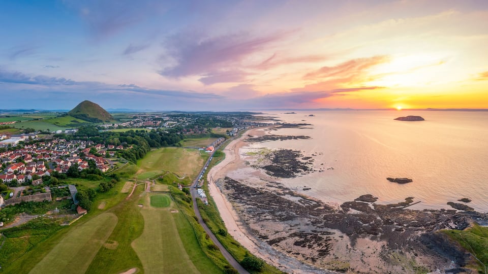 UK, Scotland, North Berwick, Aerial view of beach in front of coastal town at sunset