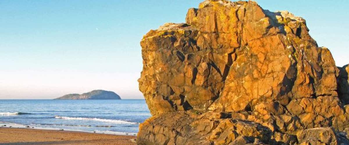Leckenbane, rock outcrop at Milsey Bay At low tide a favourite clambering site for children and dogs. The island in the picture is Craigleith. Many volunteers have spent time on the island clearing mallow which is causing a reduction in puffin numbers by blocking nesting sites.
