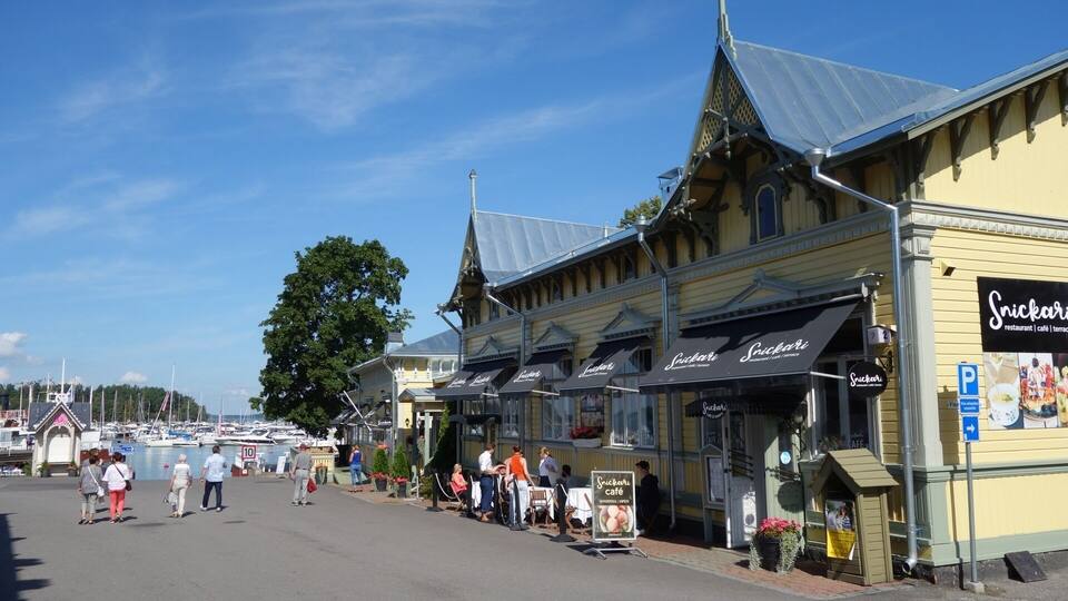 Eine Uferstraße mit Gebäuden, darunter ein Snickers Restaurant und Café.