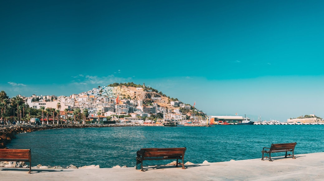 Kusadasi, Aydin Province, Turkey. Waterfront And Kusadasi Cityscape. Hand Of Peace Monument On Waterfront In Sunny Summer Day. View Of Hand Sculpture At Aegean Coast.