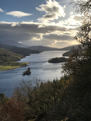 A river winding through a valley with hills and trees.