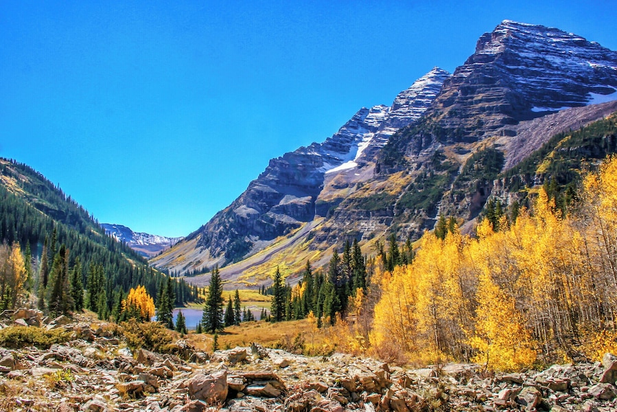 A mountain with a lake and autumn-colored trees.