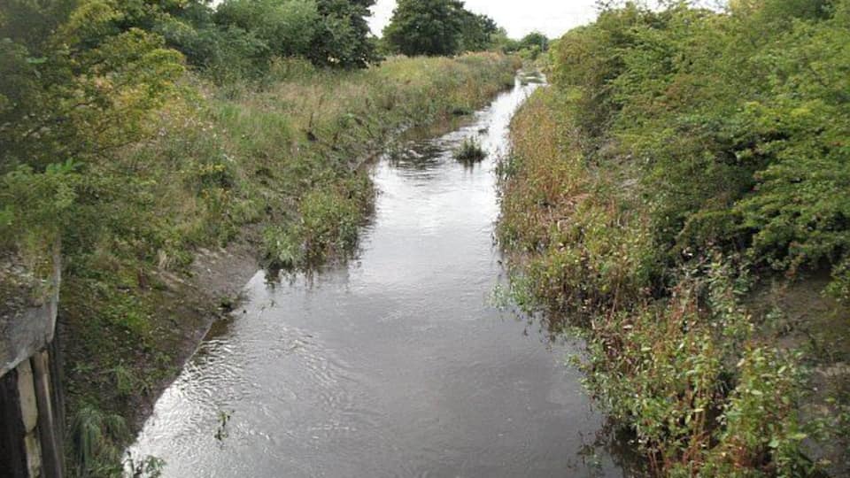 Flood relief channel, Grangemouth The town of Grangemouth is on a low lying plain between two river estuaries. To make things more interesting the Westquarter, later Grange burn flows on to the plain. To prevent frequent flooding, this burn is split into two, some of the water still flows through Grangemouth along an artificial course, and the surplus moved safely out of the way into the Avon. Looking eastwards along the relief channel which runs alongside Wholeflats Road. Vegetation shows that a lot of water had recently passed this way.