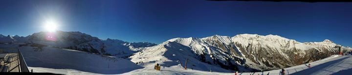A snow-covered mountain slope with a ski lift and skiers.